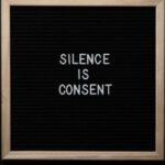 Voice Acting - From above blackboard with written phrase SILENCE IS CONSENT on center on black background