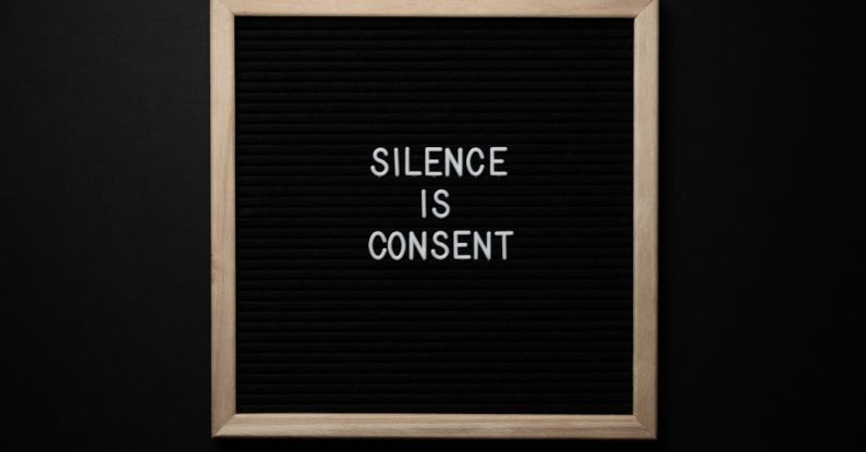 Voice Acting - From above blackboard with written phrase SILENCE IS CONSENT on center on black background