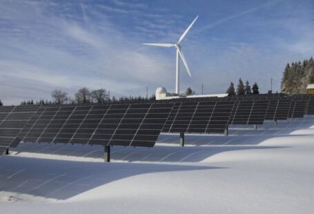 Tech Trees - Solar Panels on Snow With Windmill Under Clear Day Sky