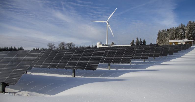 Tech Trees - Solar Panels on Snow With Windmill Under Clear Day Sky