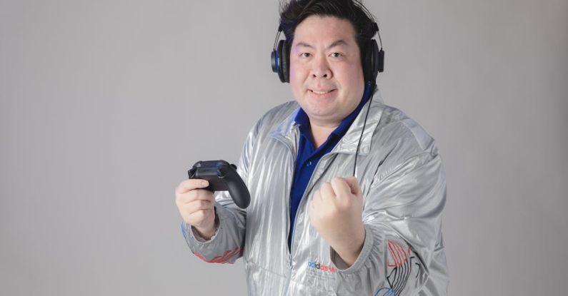 Game Endings - A man in a silver jacket holding a video game controller